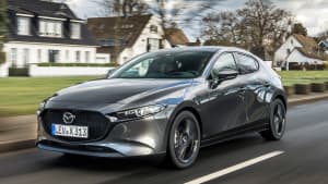 Frontansicht eines Mazda 3 Skyactive X fahrend auf einer Straße