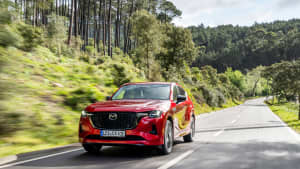 Ein roter Mazda CX 60 währdend Fahrt, frontal fotografiert