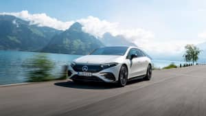Der neue weiße Mercedes EQS 580 4MATIC von der Seite während der Fahrt
