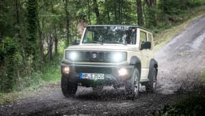 Frontansicht eines im Gelände fahrenden Suzuki Jimny