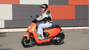 Eine Person fährt auf einem Niu MQi GT 100 Elektroroller 