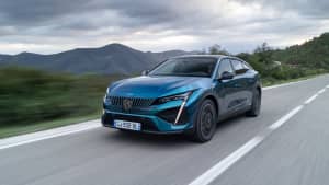 Seitliche Frontaufnahme des neuen petrolfarbene Peugeot 408 während der Fahrt