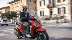 Ein Mann fährt mit dem Roller Piaggio Beverly 400 auf einer Strasse