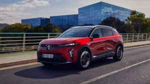 Front und Seitenansicht eines roten Renault Scenic E-Tech Electric der auf einer Straße fährt