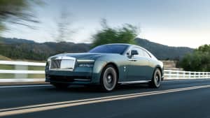 Der Rolls Royce Spectre fahrend frontal von der Seite