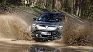 Frontansicht eines Suzuki e-Vitara der durch eine Wasserpfütze fährt