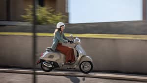 Eine junge Frau fährt die Vespa GTS 125