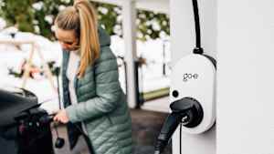 Eine Frau die Ihr Auto lädt und die go-e Wallbox im Vordergrund