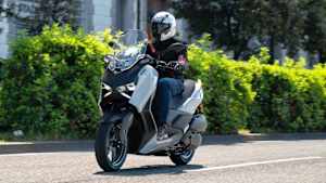 Ein Mann fährt auf einer Yamaha XMAX 300 TechMAX +