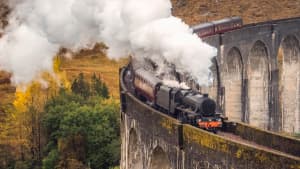 Ein Zug der West Highland Line fährt über das Glenfinnan Viadukt in Schottland
