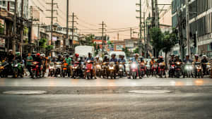 Viele Mopeds stehen auf einer stark befahrenen Strasse in Thailand