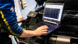 Ein Mechaniker führen Chiptuning an getunten Autos in einer Werkstatt durch