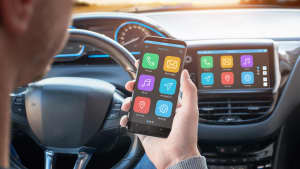 Mann verbindet sein Smartphone mit den Apps auf seinem Autodisplay