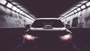 Ein schwarzes Auto leuchtet mit LED Scheinwerfern in einem Tunnel