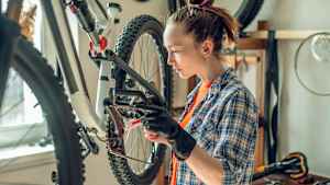 Junge Frau repariert ein Mountainbike