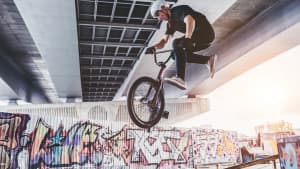 BMX Fahrer bei Trick auf seinem Fahrrad