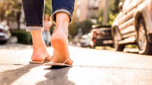 Eine Frau läuft mit Flip Flops über eine Strasse