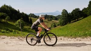 Eine Frau die auf einem Gravel Bike durch die Berger fährt