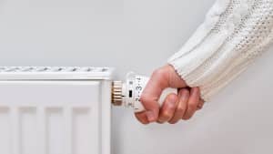 Close uo einer Hand, die die Heizung aufdreht
