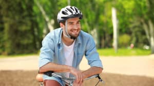 Ein junger Mann mit Fahrradhelm lächelt