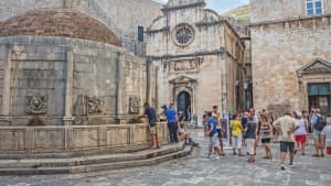 Blick auf einen Brunnen mit vielen Menschen in Dubrovnik