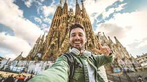 Ein junger mann macht ein Selfie vor der La Sagrada Familia in Bacelona