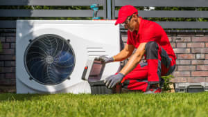 Ein Handwerker installiert eine Wärmepumpe
