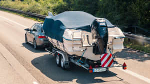 Ein grauer PKW mit einem Bootsanhänger und grünem Kennzeichen