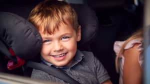 Ein kleiner Junge sitzt in einem Kindersitz im Auto