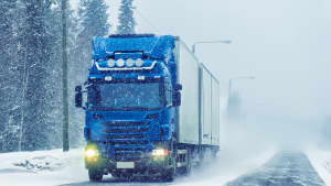 LKW fährt auf schneebedeckter Straße