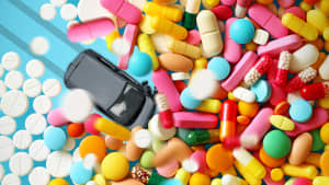 Ein Spielzeugauto fährt in einen Haufen von Bunten Tabletten
