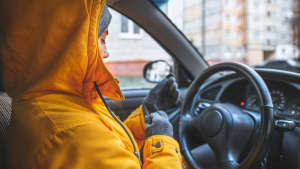 Frau lässt Motor im Auto warm laufen