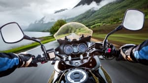 Ein Motorradfahrer fährt bei Nebel auf einer Straße