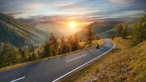 Motorradfahrer auf einer Passstraße im Herbst