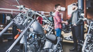 Zwei Männer in einem Motorradladen schütteln sich die Hände.