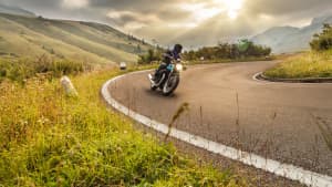 Motorradfahrer kurvt auf Landstrasse im Alpenvorland