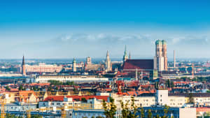 Panoramaansicht von München mit der Frauenkirche und im Hintergrund sieht man die Alpen