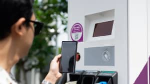 EV-Fahrer verwenden Smartphone, um QR-Code auf Elektrofahrzeug-Ladestationen zu scannen