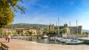 Ein Paar spaziert am Hafen von Torri del Benaco  am Gardasee