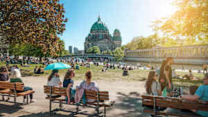 Menschen genießen die Sommersonne auf der Museumsinsel in Berlin