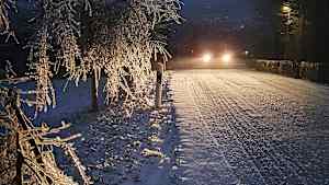 Ein Auto fährt durch eine Winterlandschaft