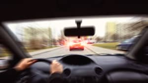 Blick aus einem fahrenden Auto auf Bremsenden Vordermann