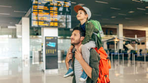 Vater trägt Kind auf der Schulter am Flughafen