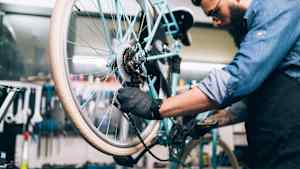 Der Schaltzug am Fahrrad wird von einem Mann repariert