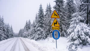 Verschneite Strasse mit Verkehrsschild