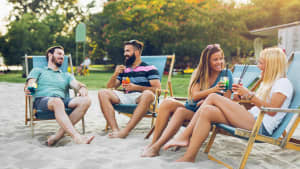 Eine Gruppe von Freunden die zusammensitzt und Cocktails trinkt