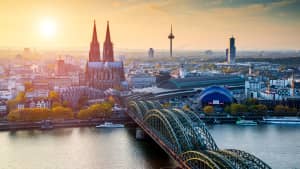 Der Kölner Dom und die Hohenzollernbrücke mit der Skyline von Köln in der Dämmerung