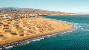 Drohnenaufnahme mit Dünen, Meer und Maspalomas im Hintergrund