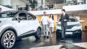 Autohändler berät Paar bei Autokauf