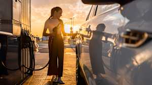Eine Frau betankt ihr Auto an einer Tankstelle mit Benzin